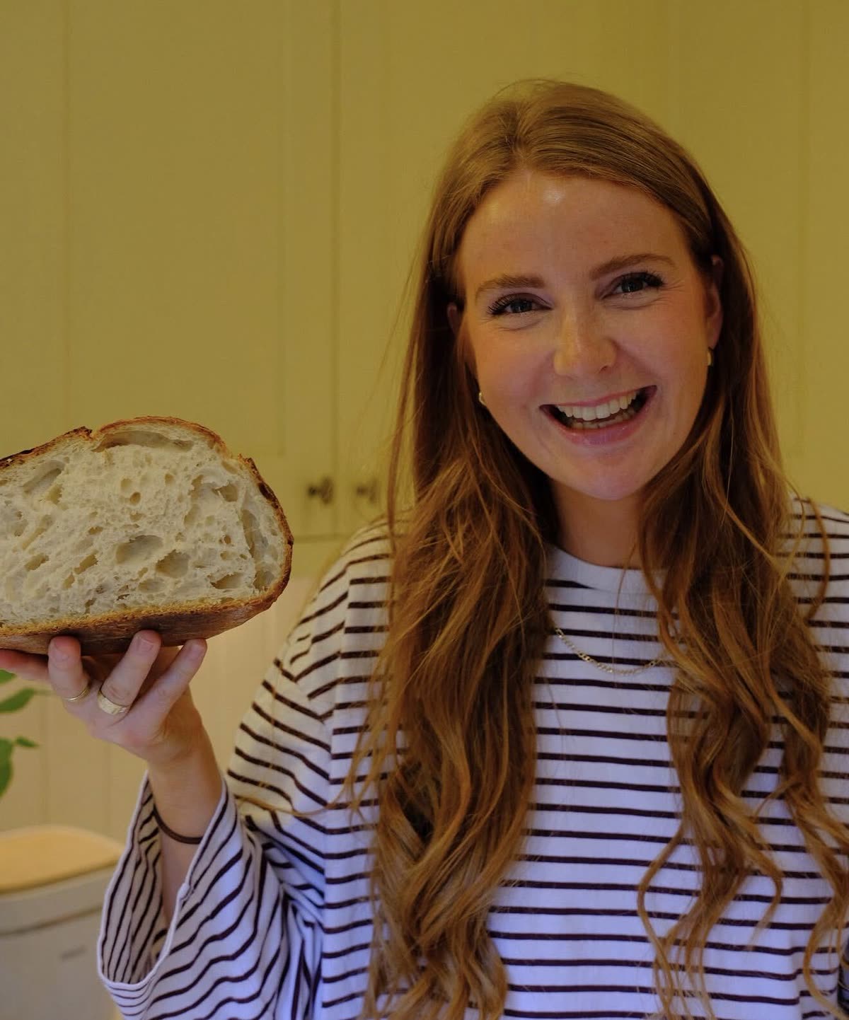 Jess holding up a slice of sourdough with an open, airy crumb